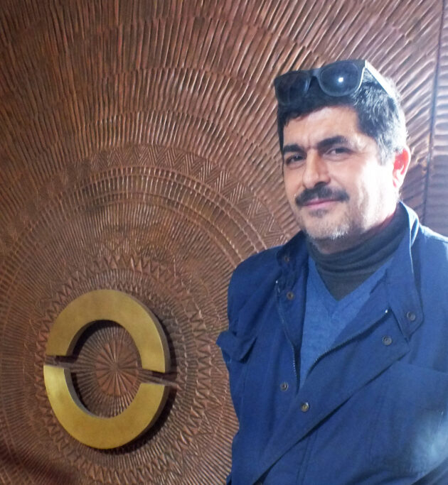 Radwan Hassoun in front of a large brass and copper door he had made for a Beirut Mansion